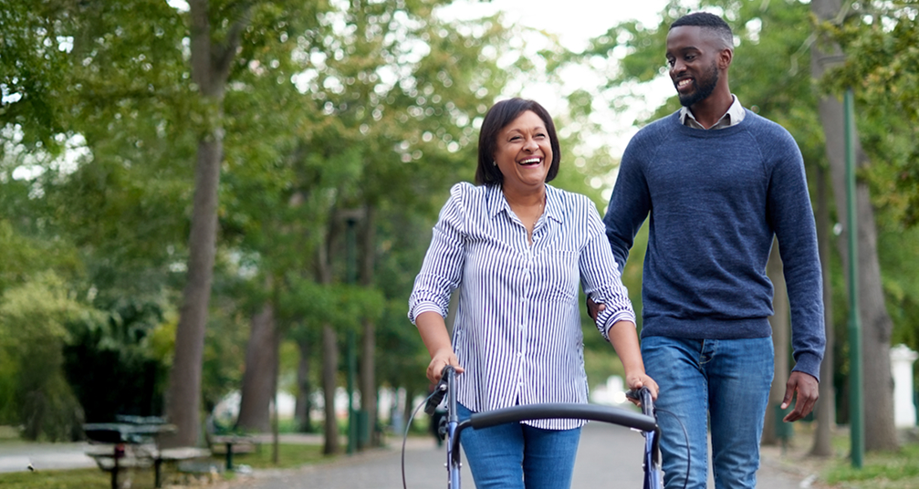 Smiling woman with walker and a younger male laughing