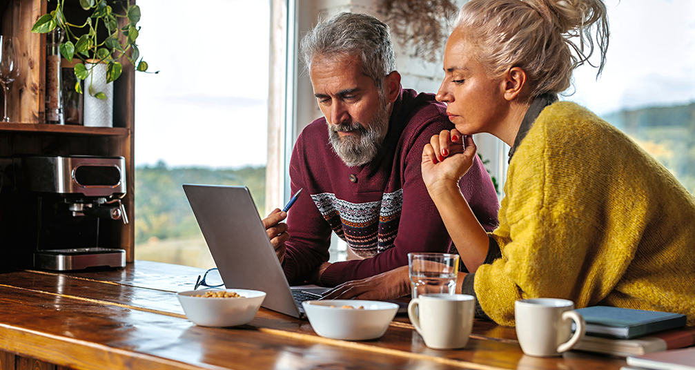 Couple at a table looking at a laptop