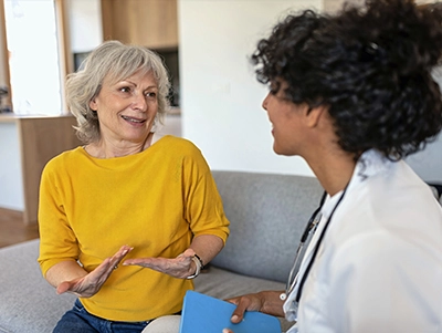Doctor talking to a woman on a couch