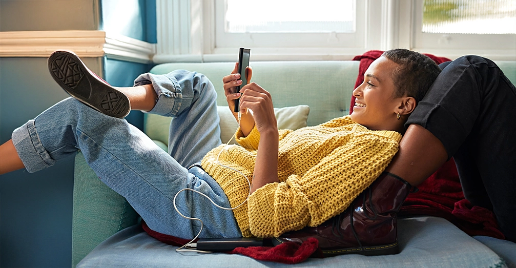Woman lying on a couch looking at her phone
