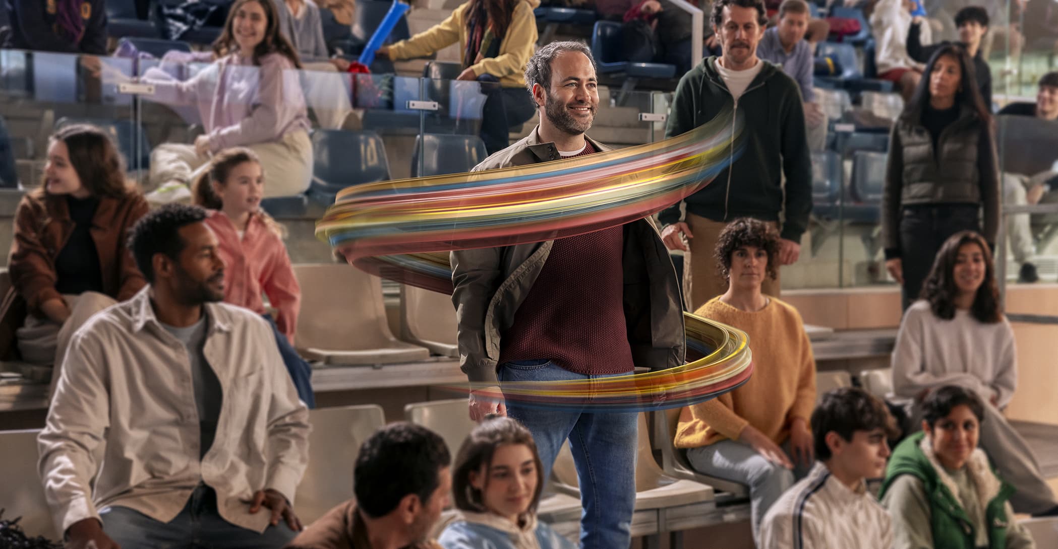 Man standing smiling as part of an audience for a game