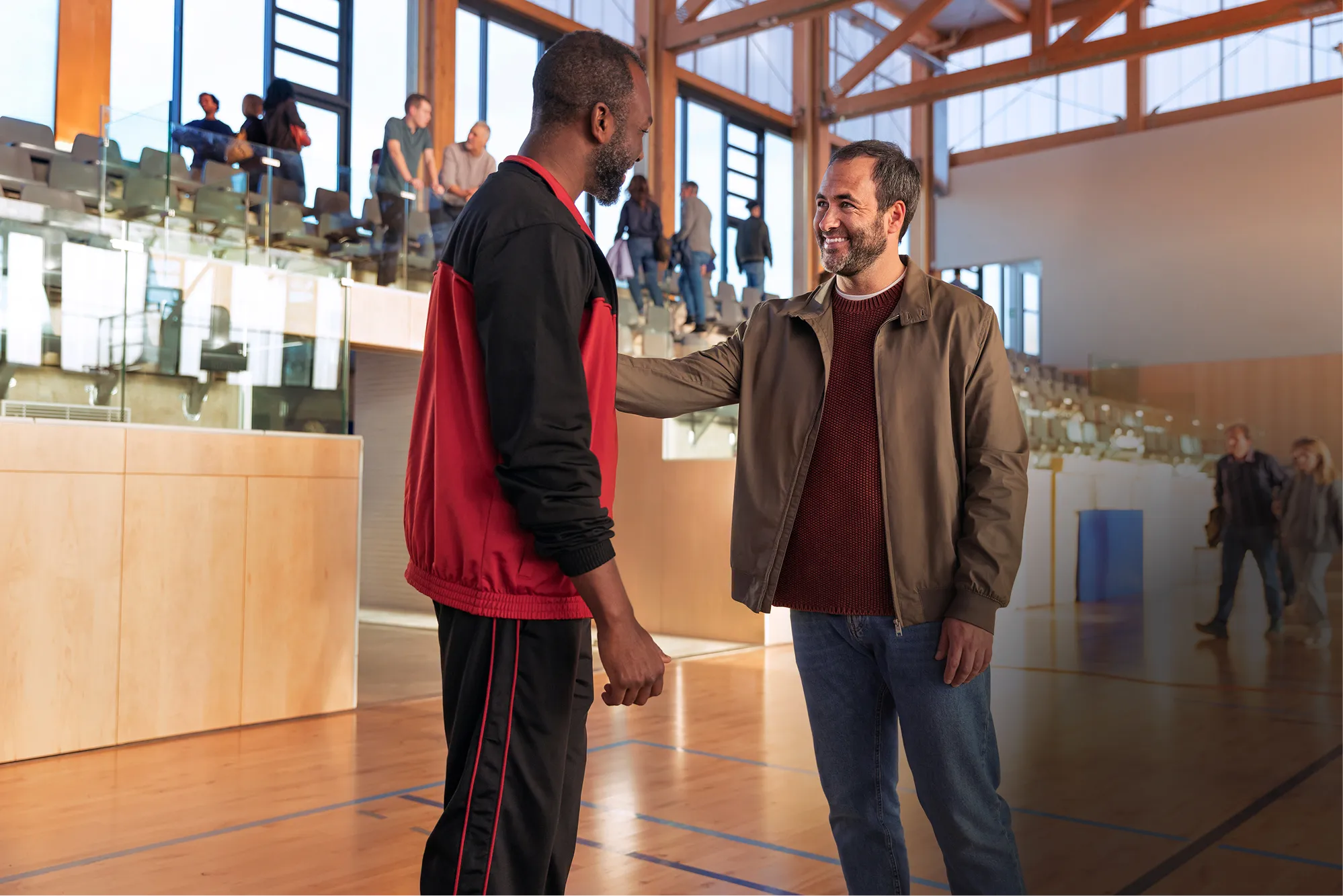 Man standing smiling as part of an audience for a game